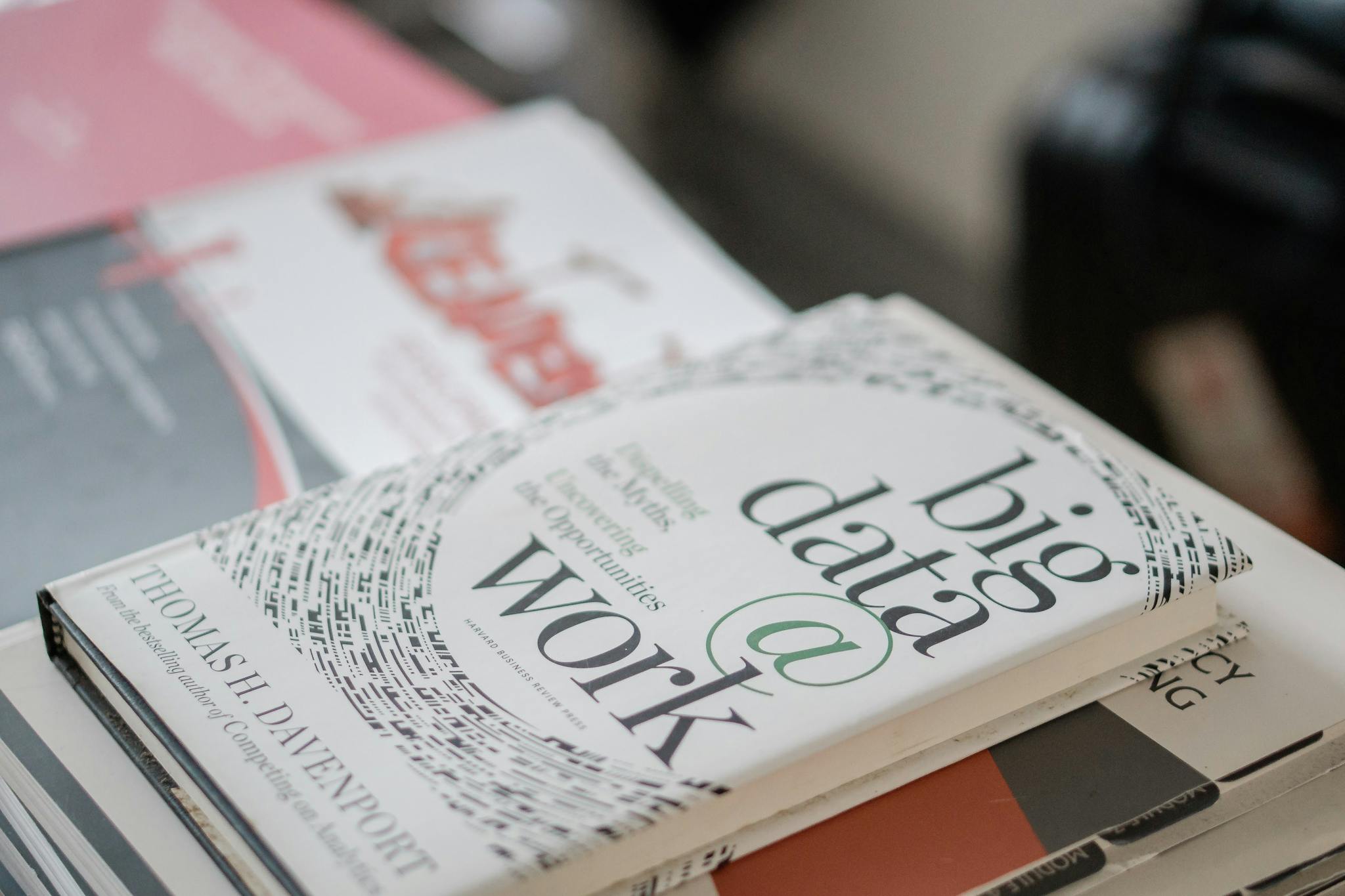 Close-up of books on data analytics and business strategies on a desk.